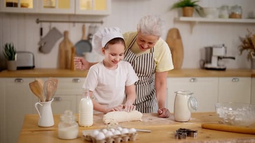Child and Senior Baking Together in Kitchen