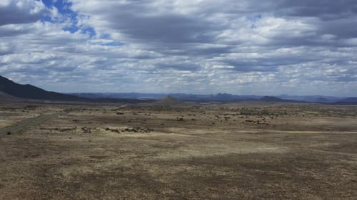 Aerial slow backwards tracking shot of a moody cloudy desert landscape in the Karoo, South Africa.
S