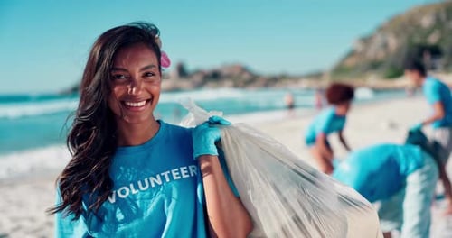 Volunteer, woman and face with plastic bag at beach for ocean cleanup, waste management
