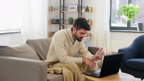 Man on Couch Telemedicine Consultation With Medication