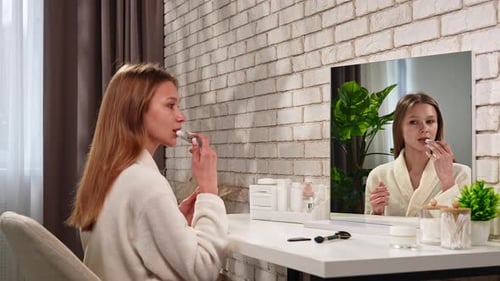 Woman Applying Lip Balm at Vanity in Modern Bathroom