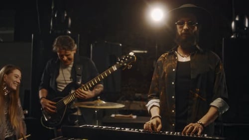 Male Musician Posing in Studio while Bandmates Talking in Background