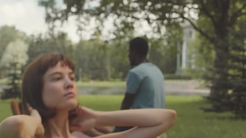 Young Adults Exercising Together in a Green Park