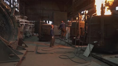 Foundry Workers Casting Molten Metal Into a Mold Stock Clip