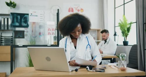 Female Doctor Working at Laptop in Modern Office