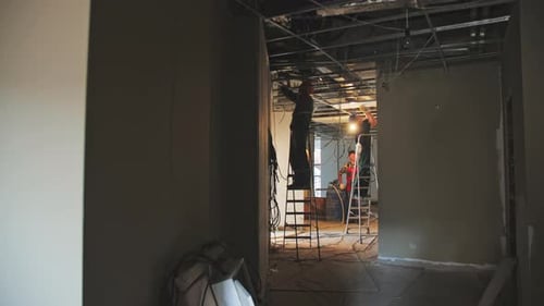 Repairmen Conduct Installation Works in Public Building