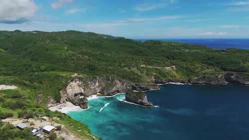Dolly aerial over Manta Bay cliffs and bright turquoise water, Nusa Penida, Bali