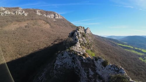 Un Drone survole une zone rocheuse au sommet d'une montagne et soudain, un oiseau ou un vautour prend peur