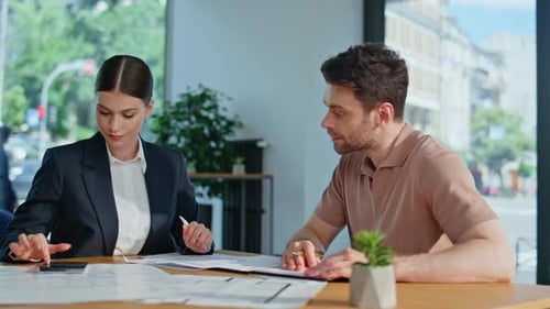 Buchhalterin erklärt dem Mann im Büro den Bericht aus der Nähe des Finanzunternehmens