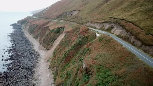 Car driving in Ireland next to the ocean, dingle peninsula.