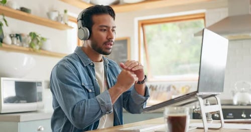Man Teleconferencing on Laptop in Bright Kitchen