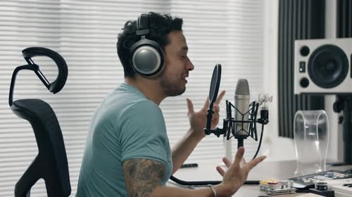 Man talking into microphone, expressing ideas and working in a professional home studio