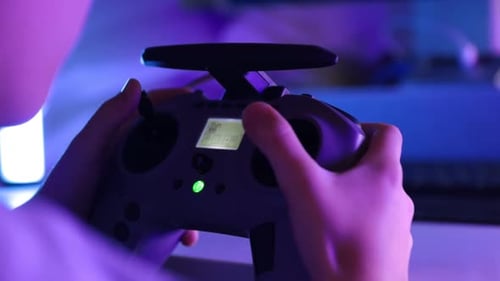 Hands Holding Controller in Dark Gaming Room