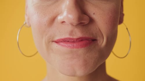 Detailed close-up shot of woman's smile isolated on yellow background