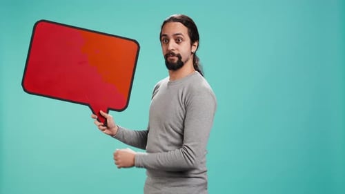 Man Holds Red Speech Bubble Against Blue Background