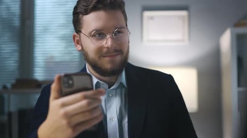 Businessman Using Smartphone in Office