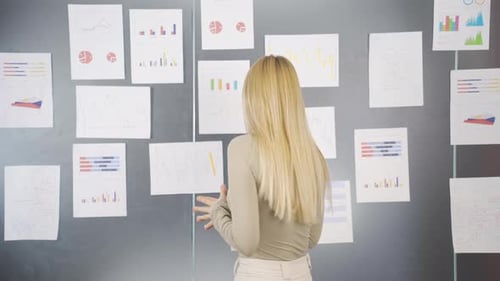 Woman Analyzing Data on Office Wall