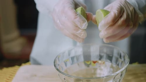 Female Hands Squeeze Lime Halves to Obtain Juice Lime Juice Pours Into a Glass Bowl