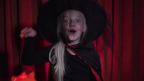 Girl Dressed as Witch Holding Jack-o'-Lantern