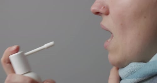 Woman Sprays Sore Throat with Medicine