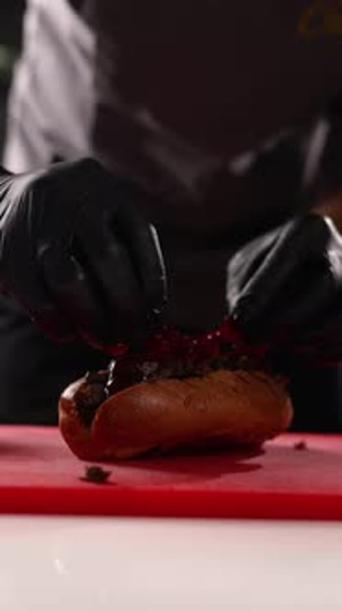 A chef prepares delicious hot dogs in a restaurant.