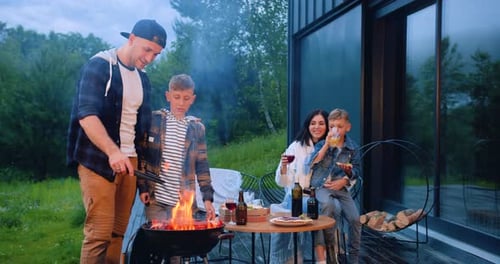 Family Enjoys an Outdoor Barbecue by Their Home