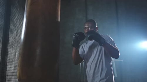 Fitness Workout in Gym Strong African Man Fighter Training Punches with Boxing Bag Healthy Boxer Man