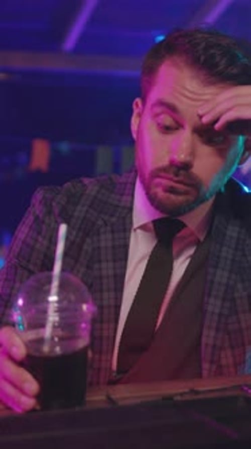 A Thoughtful and Pensive Man Savoring His Drink in a Chic and Stylish Bar Setting