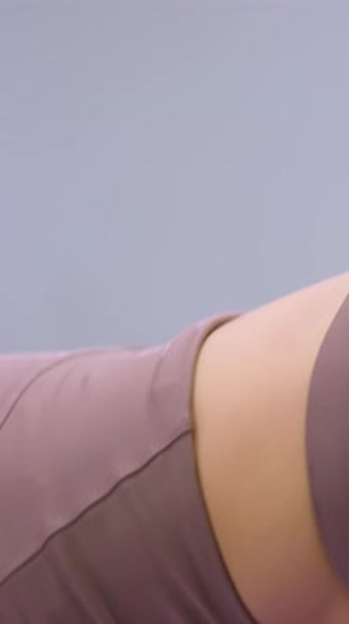 CloseUp of Woman Engaging in Flexibility Exercise with Light Reflection in Gym