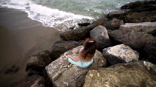 Woman Doing Yoga on Rocks at the Beach