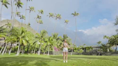 A Woman is Enjoying the Beauty of a Tropical Beach with Palm Trees on a Sunny Day