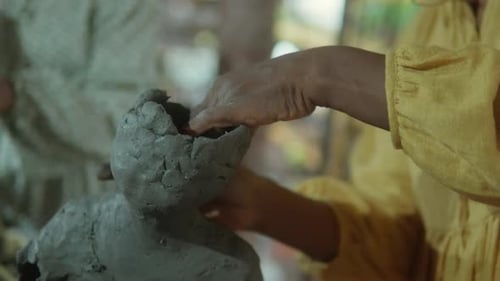 Artist Sculpting Gray Clay Forming Art with Hands