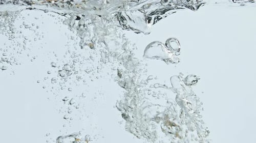 Lemons Dropping Into Water with Bubbles and Splash