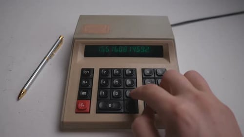 Hand Typing on Old Calculator for Finance
