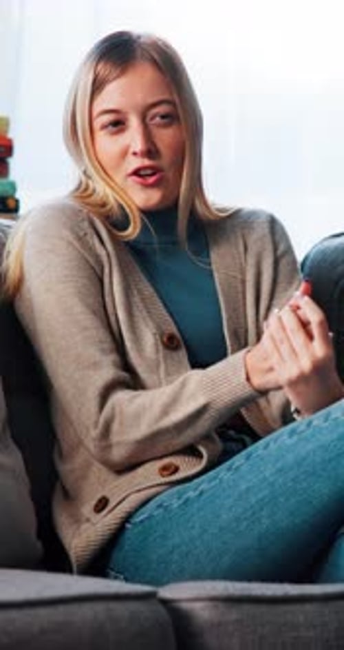 Young Woman Chatting on Couch Indoors