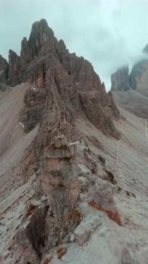 FPV-Drohne, die entlang der Oberfläche der Bergklippen des Cristallo-Berges fliegt