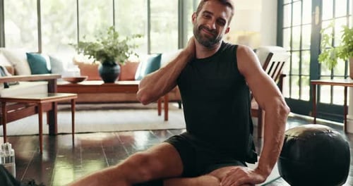 Man Stretching Neck in Bright Living Room