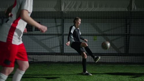 Little Girls Soccer Players Training In Indoors Sports Arena Catching And Kicking Ball