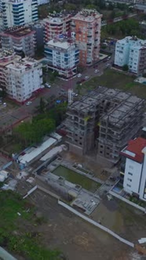 Vídeo vertical Una obra de construcción concurrida con trabajadores que realizan múltiples tareas y maquinaria en