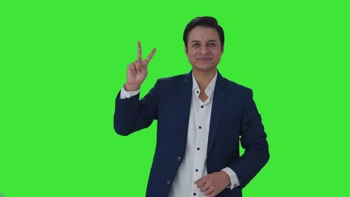 Feliz periodista indio mostrando el signo de la victoria Pantalla verde