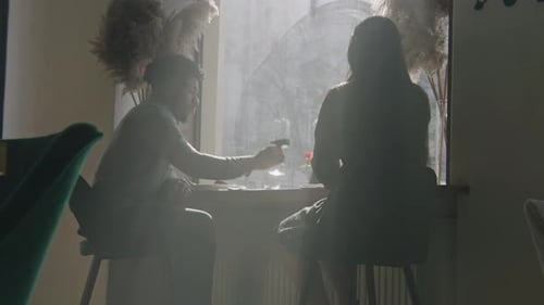 Couple multiethnique qui trinque des verres et boit
