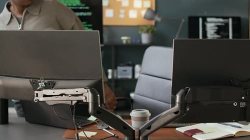 Junge schwarze Softwareingenieurin nimmt am Schreibtisch Platz