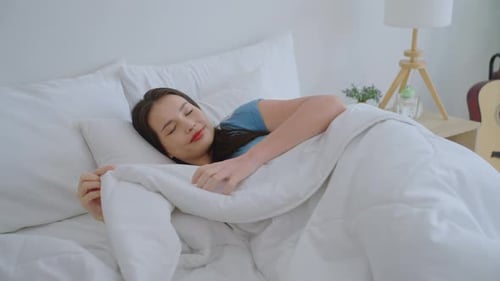Peaceful Woman Sleeping Comfortably in Bed at Home