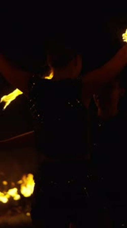 Dynamic Night Fire Performance with Two Skilled Performers Spinning Flaming Props in Synchronized
