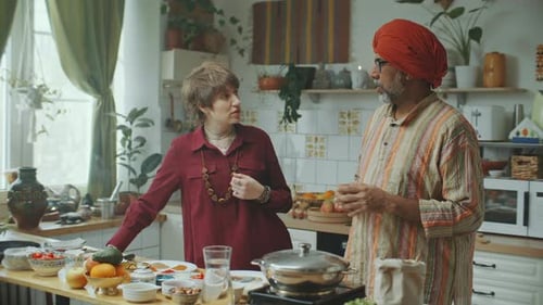 Two Adults Conversing in Kitchen with Ingredients