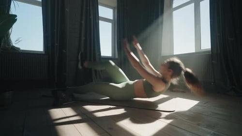 Entrenamiento físico intensivo en casa para mujer joven entrenando mediante tutoriales en Vídeo de un entrenador profesional