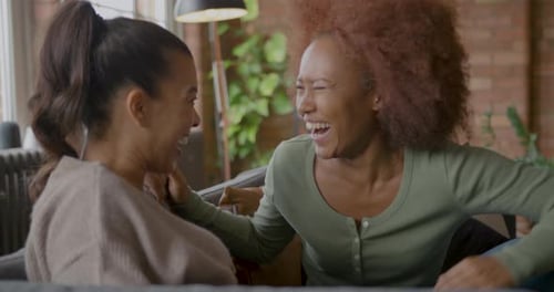 Friends Chatting and Laughing on Couch Indoors