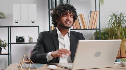 Young Adult Working at Desk on Laptop Computer