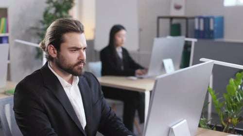 Man in Formal Suit Typing on Computer Keyboard at Office