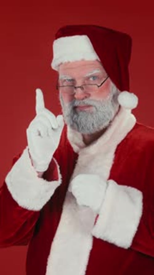 Vertical of Strict Santa Claus Wagging Finger on Red Background